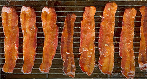 Succulent candied bacon strips glistening with a glaze of maple syrup and brown sugar, smoked on a Z Grills pellet grill.