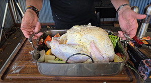 Seasoned turkey stuffed with vegetables on a rack, ready for roasting